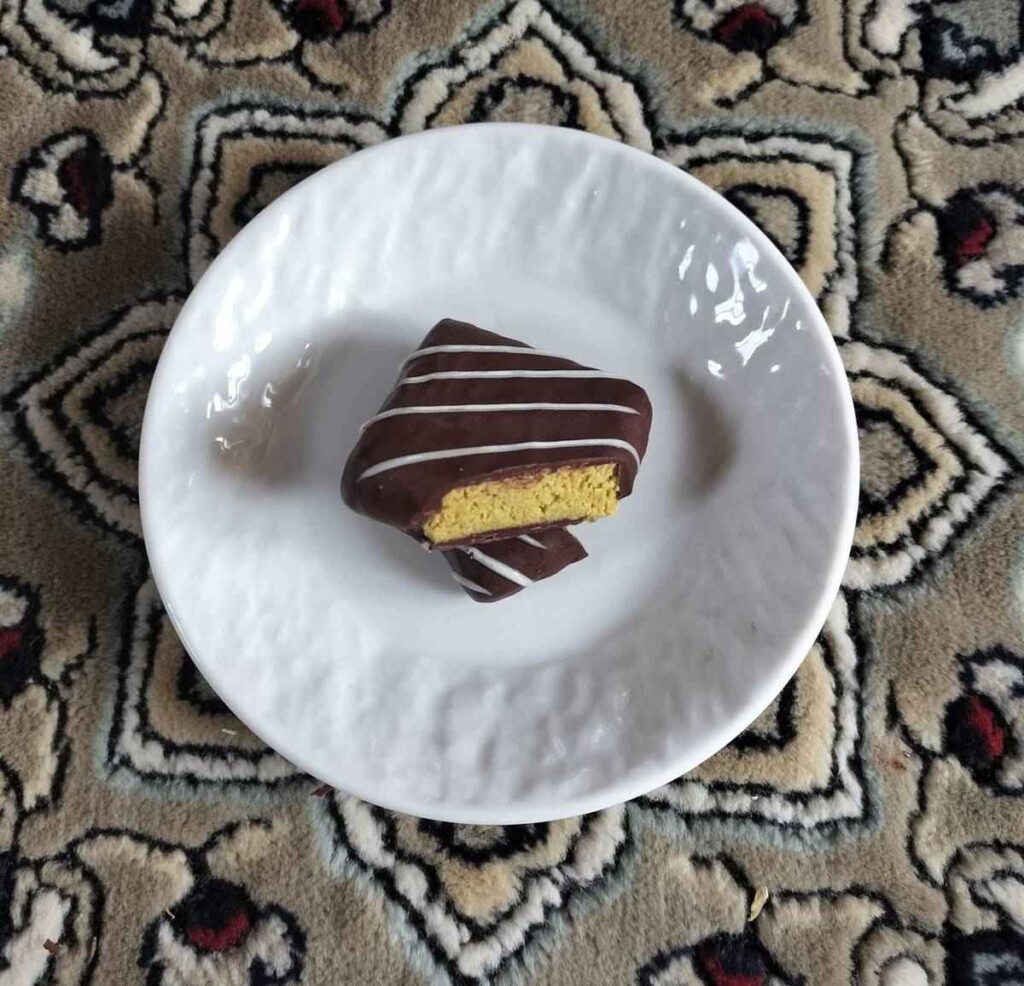 A Japanese-made Dubai-style chocolate snack on a white plate with a patterned carpet background